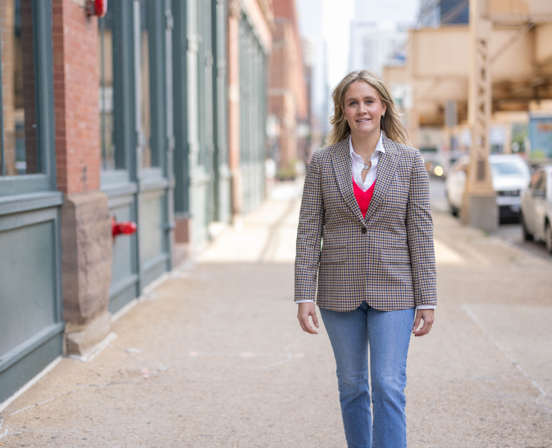 Young woman walking downtown Chicago in brown blazer and jeans
